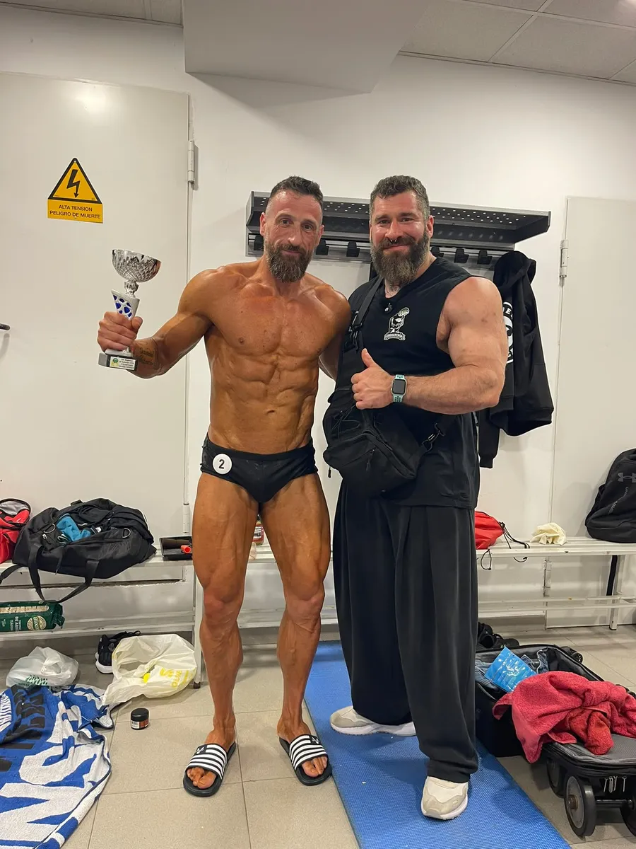 Esneider con un cliente que acaba de competir, con su trofeo